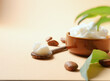 Unrefined shea butter with nuts and leaves on beige light background.