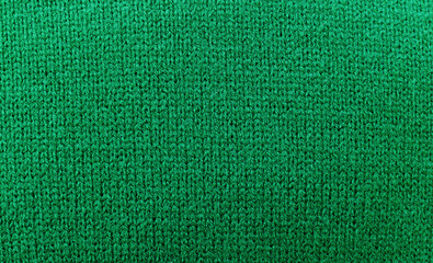 Green sweater knitted texture background, close up, top view, copy space.