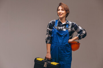 Woman repairer wearing overalls uniform and holding repair tool box