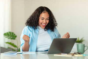 Wall Mural - Joyful African American Businesswoman At Laptop Gesturing Yes In Office