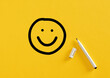 © Cagkan - Smiling happy face sketch hand drawn with a felt tip marker pen on yellow background. Client satisfaction, service or product evaluation