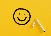 Smiling Happy Face Sketch Hand Drawn With A Felt Tip Marker Pen On Yellow Background. Client Satisfaction, Service Or Product Evaluation