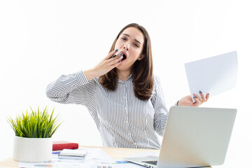 Wall Mural - A young woman yawns while sitting at her workplace. Tired office worker. Studio business photo