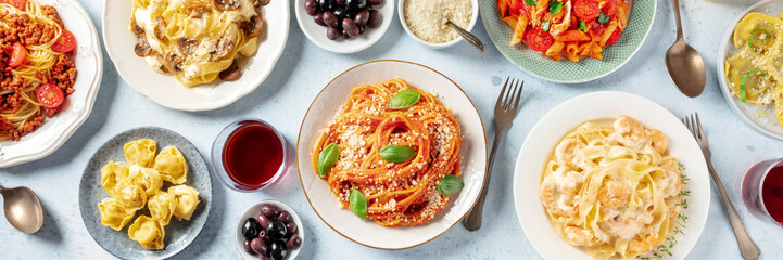 Wall Mural - Pasta panorama. Assortment of Italian pastas, with spaghetti Bolognese, seafood pasta, penne with chicken, tortellini, ravioli and others, overhead flat lay shot with wine and olives