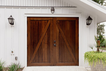 a large set of stained dark wood garage door on a public building