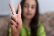 © Angelov - gesture and happy people concept - smiling little girl in blank t-shirt showing peace gesture with fingers