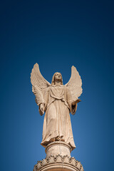 Wall Mural - Cover page with statue of winged angel at Evangelical church Saint Nikolai at blue sky gradient background with copy space, Potsdam, Germany