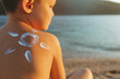 © Jelena Stanojkovic - Rearview shot of a little boy sitting at the beach with sunscreen lotion on his back.