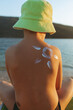 © Jelena Stanojkovic - Little boy with his back turned and sunscreen lotion on the skin. Closeup of shoulder boy with sun design made with sunscreen.