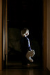 Toddler boy, hodling teddy bear, standing in hallway next to the door to bedroom, fairy tale picture