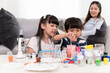 © chachamp - Daughter and son funny learning study science and test chemical with mother background at home