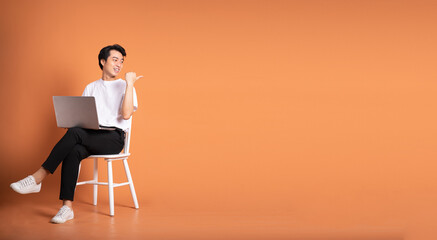 Wall Mural - man sitting on chair  isolated on orange background