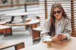 © Petro - Business woman in a cafe drinking coffe, using phone