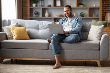 Wall Mural - Freelance Concept. Happy Young African American Man Using Laptop At Home