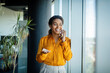 © Prostock-studio - Mobile call. Positive black businesswoman talking on cellphone and smiling, having pleasant phone conversation in office