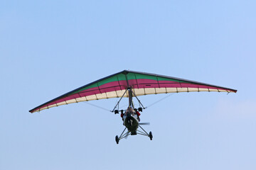 Poster - Ultralight airplane flying in a blue sky