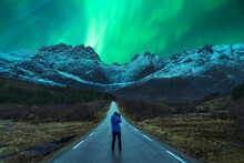 Traveler Standing On Road Under Sky With Aurora