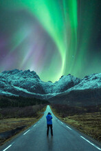 Traveler Standing On Road Under Sky With Aurora