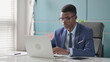 © stockbakers - Young African Businessman Working on Laptop in Office