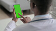 © stockbakers - Young African Doctor using Smartphone with Chroma Screen
