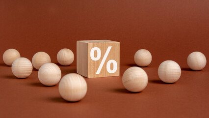 Wall Mural - percent sign on wooden cubes against broun background with wooden balls. concept of sale and discount