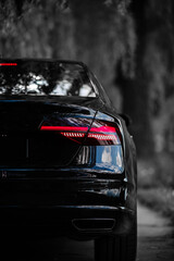 Wall Mural - Rear light of a modern black car. Detail of car. Concept of expensive, sports auto.