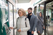 © JackF - Elegant middle aged woman using ticket vending machine at city tram stop in autumn day..
