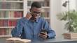 © stockbakers - Successful Young African Man Celebrating on Smartphone