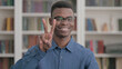 © stockbakers - Young African Man showing Victory Sign with Fingers