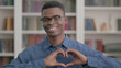 © stockbakers - Young African Man showing Heart Shape by Hands