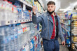 © JackF - portrait of young bearded man buying still water in grocery section at supermarket