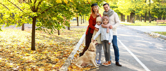 Portrait of happy family walking in autumn park