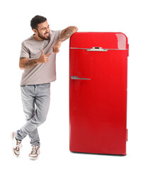 Poster - Cool tattooed young man near red fridge isolated on white