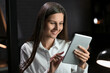 © Pixel-Shot - Smiling businesswoman working with tablet computer in office at night
