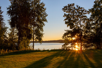 Wall Mural - Sunset scenery on an autumn evening in Finland. Lake shore wallpaper concept image. Some flare effect added to images.