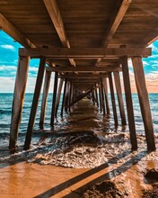 Vertical Shot Of The Underside Of A Wooden Pier In A Beach