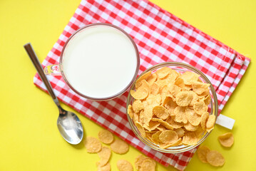 Wall Mural - cornflakes bowl breakfast food and snack for healthy food concept, morning breakfast fresh whole grain cereal, cornflakes with milk on yellow background - top view