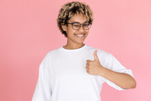 Portrait Of Satisfied African American Woman. Female Model In Glasses With Curly Hair Looking At Camera, Gesturing. Portrait, Studio Shot, Emotion Concept