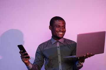 Wall Mural - african man using a phone and laptop