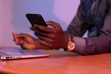 Wall Mural - black businessman using his phone and credit card