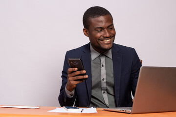 Wall Mural - black businessman using his phone and laptop