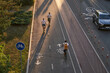 © nuclear_lily - Top aerial view of cyclist and two mans are riding on kick scooters on cycling road.