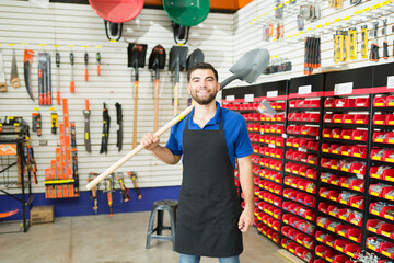 Wall Mural - Retail worker looking happy before showing a new shovel to a customer