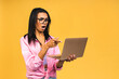 Shocked amazed african american black business or student woman, posing isolated on yellow background. Mock up copy space. Working on laptop pc computer.