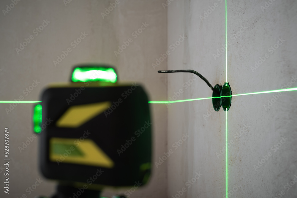 Foto Electrical wiring work on the wall using laser level device ...