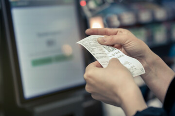 Point of Sale System For Retail product receipt in women's hands in the store - Credit Card Processor, Receipt Printer with paper shopping bill and Touch screen monitor