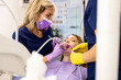 © Zoran Zeremski - Female dentist with assistant working in dental clinic examining patient teeth.