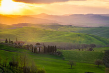 Sunrise Over A Lone Farm In The Middle Of The Hills Of The Tuscany Countryside,  Italy