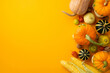 Autumn harvest concept. Top view vertical photo of raw vegetables pumpkins pattypans corn walnuts and physalis on isolated orange background with copyspace