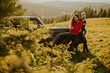 © BGStock72 - Smiling couple preparing hiking adventure with backpacks by terrain vehicle